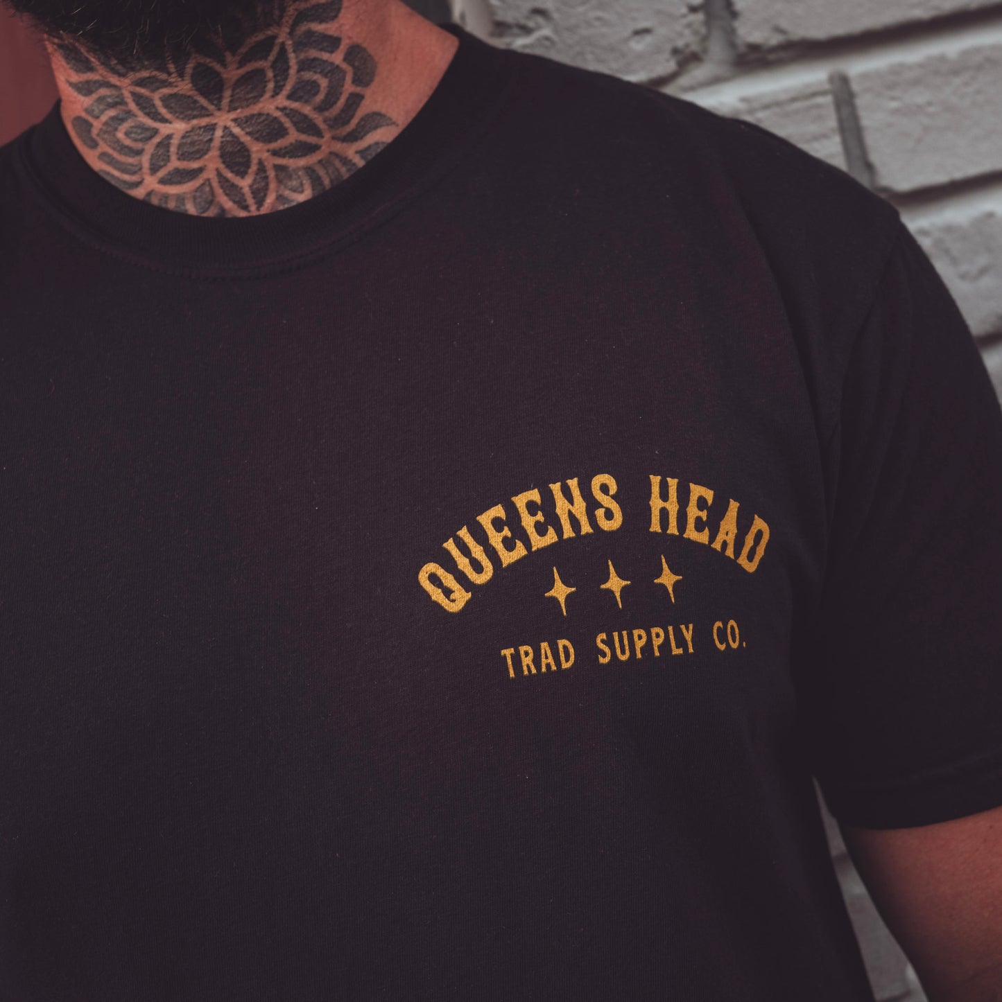 tattooed model wearing Queens Heads painted lady tattoo graphic tee, American traditional design in black.
