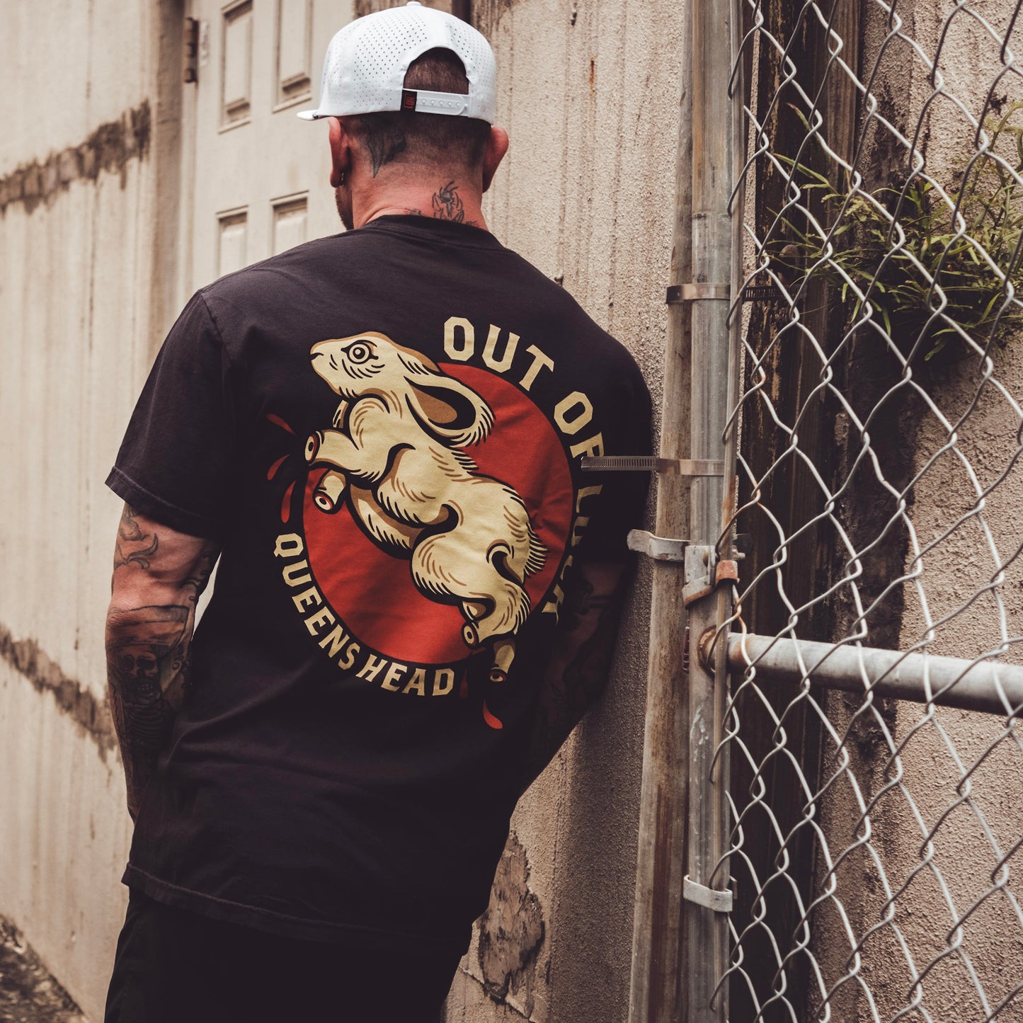 Model wearing Queens Heads Out of Luck tattoo graphic tee, American traditional design in black.