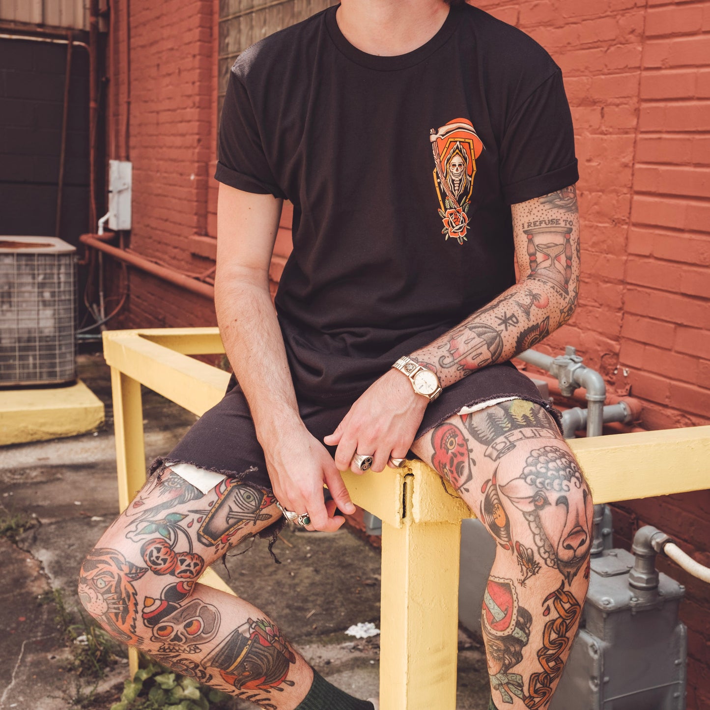 Model wearing Queens Heads Reaper tattoo graphic tee, American traditional design in black.